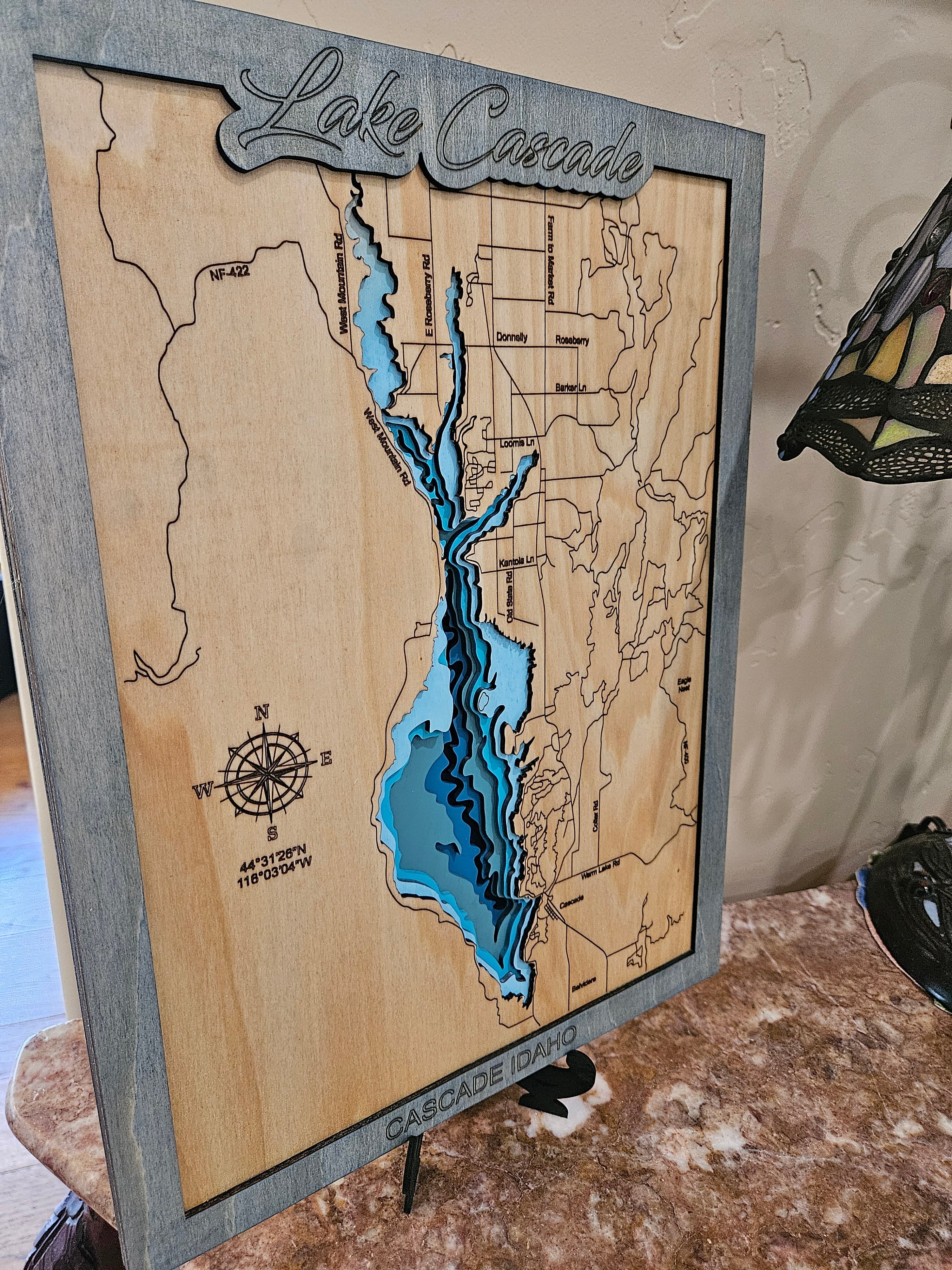 Laser-cut Lake Cascade map in layered birch with blue depth effect and weathered gray frame, Cascade Idaho
