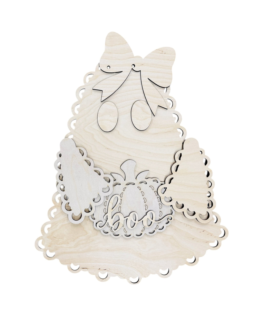 A light natural wood ghost-shaped decorative plaque with laser-cut details, including a bow, eyes, wings, and a pumpkin with the word 'boo' in the center, shown on a plain white background.