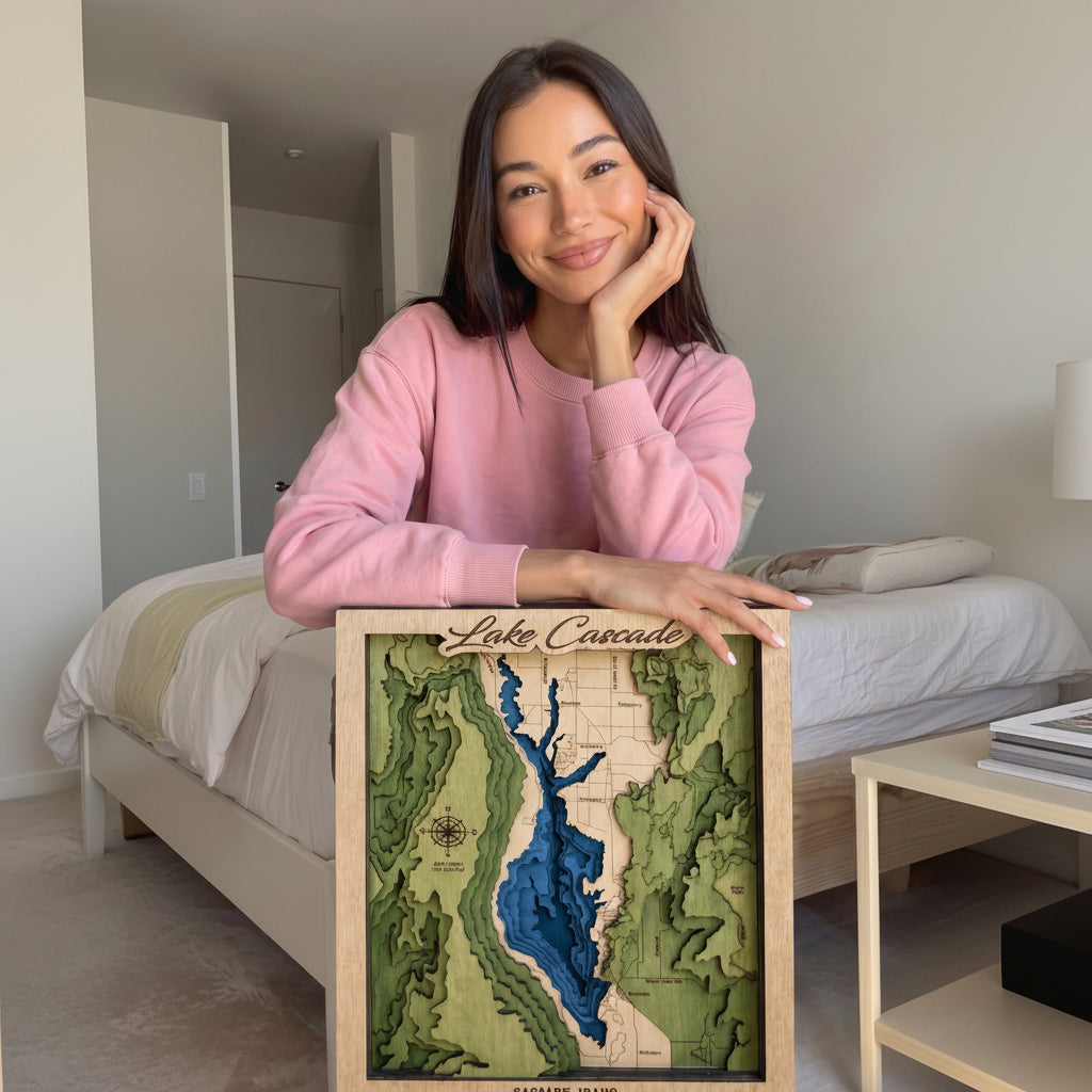 Woman holding a framed topographic map of Lake Cascade in a room.
