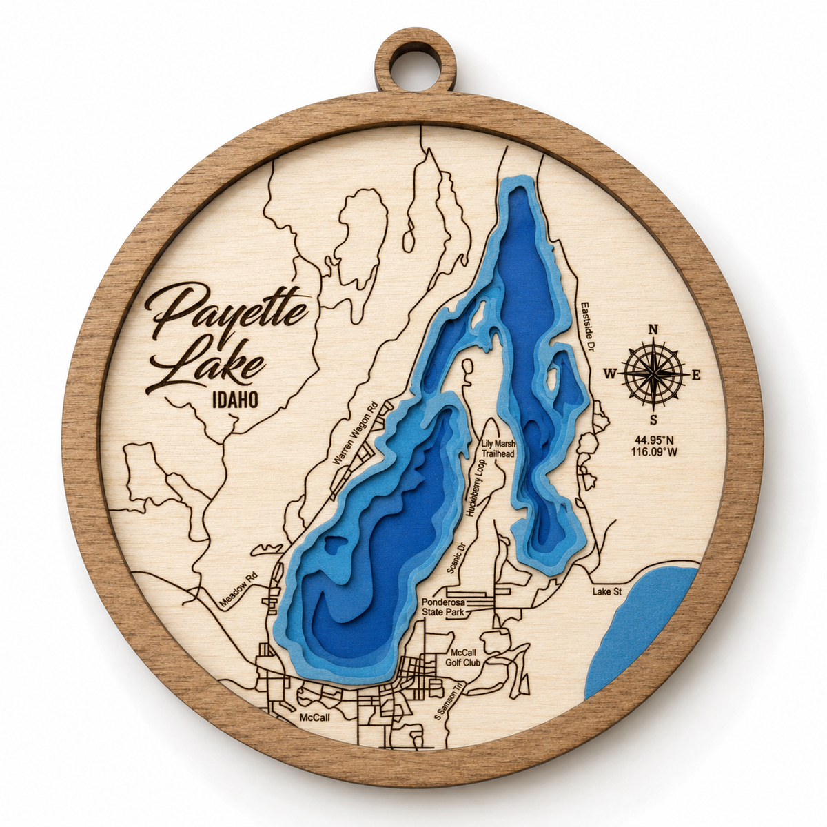 A round wooden plaque featuring a 3D layered map of Payette Lake, Idaho. The natural wood frame and map outlines are contrasted with vibrant blue and medium-dark blue layers representing the lake's depth, along with a printed compass rose and location text.