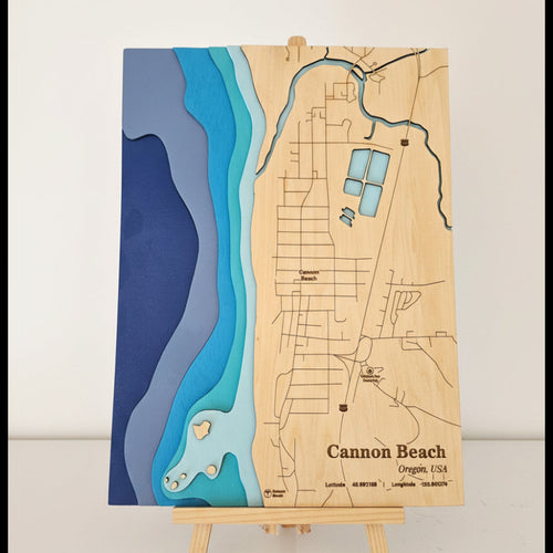 Wooden map of Cannon Beach on an easel against a white background